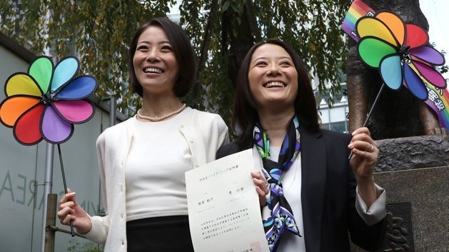 Japanese gay couple Hiroko Masuhara (R) and Koyuki Higashi display a certification paper of "partnership" issued by the Shibuya ward office after they received it in Tokyo on November 5, 2015. While the certificates are not be legally binding, the district hoped they would encourage hospitals and landlords to ensure same-sex couples receive similar treatment to married people. AFP PHOTO / Yoshikazu TSUNO        (Photo credit should read YOSHIKAZU TSUNO/AFP/Getty Images)